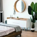 Minimal bedroom with round mirror and plant